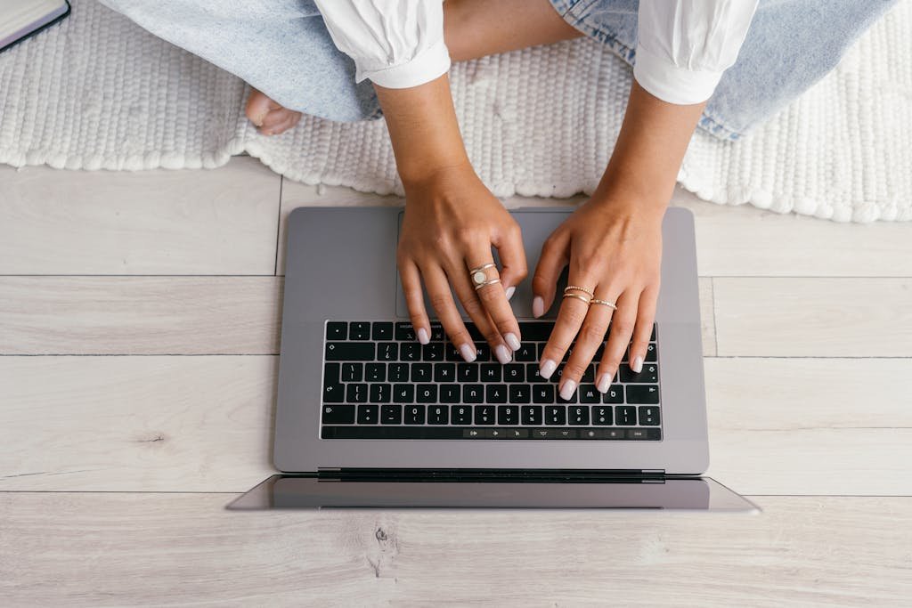 Unrecognizable woman typing on a laptop, working remotely from home.