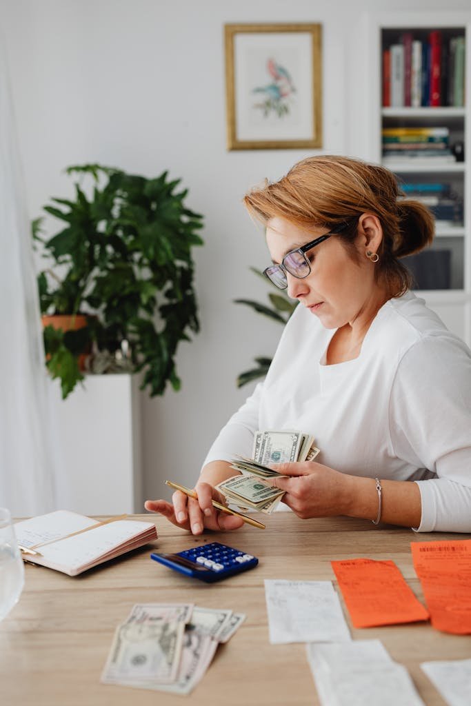 Woman in modern living room counting money and managing bills.