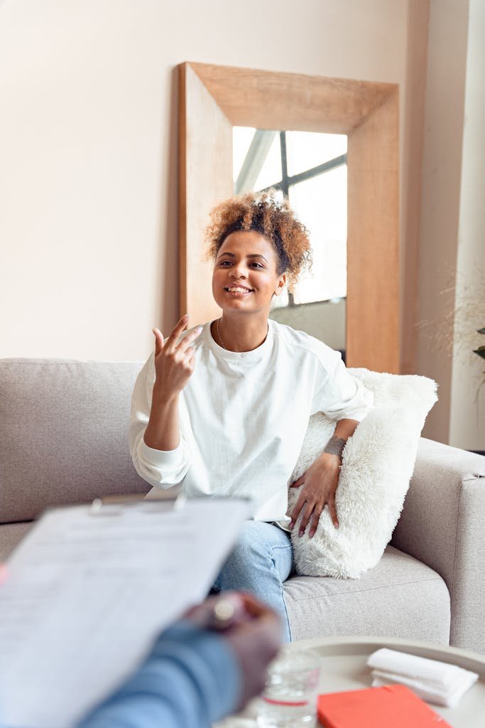 Smiling woman in a therapy session on a comfortable sofa.