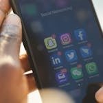 Close-up of a smartphone showing various social media applications being used.