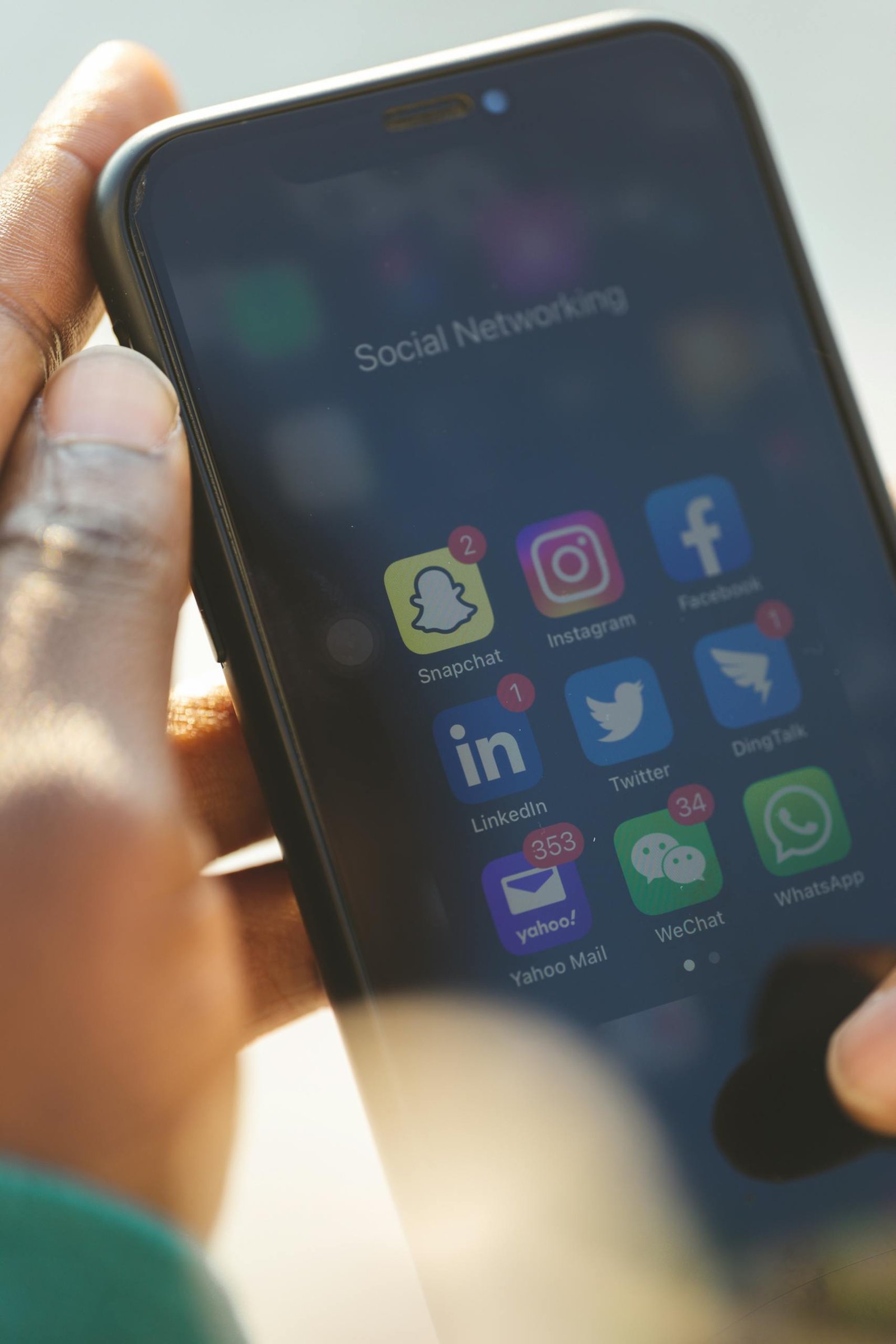 Close-up of a smartphone showing various social media applications being used.